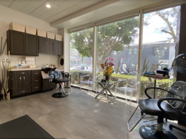 Bright salon with large window, modern furniture, and relaxing vibe.